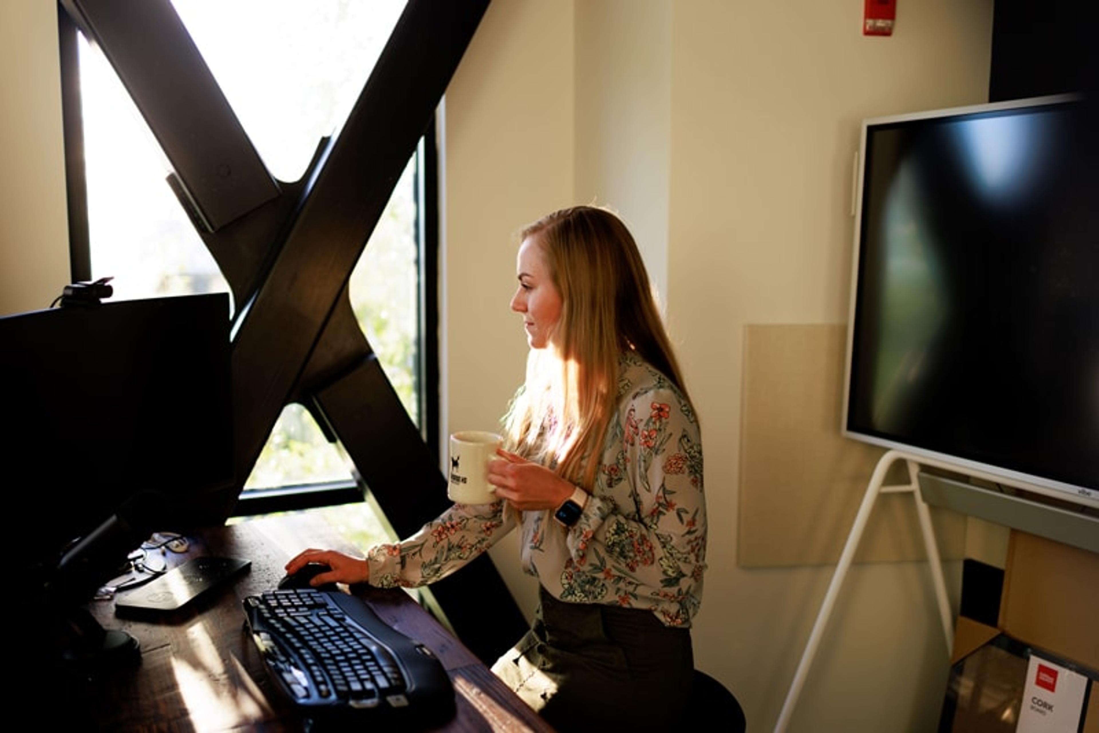 Woman looking at monitor in a small office space in Edmonds at Workhorse Coworking