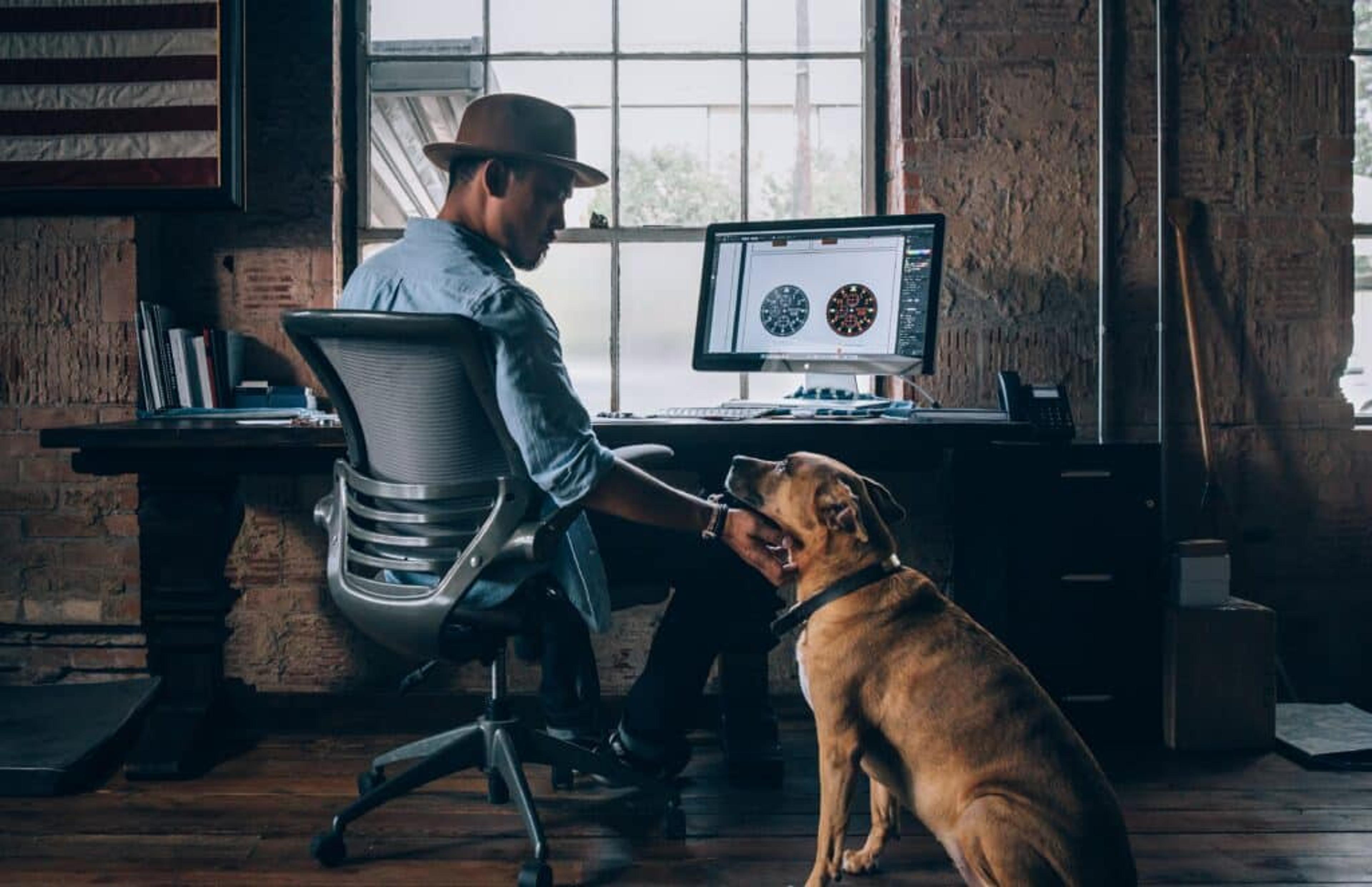 A man pets his loyal canine companion after a long day of work at the office