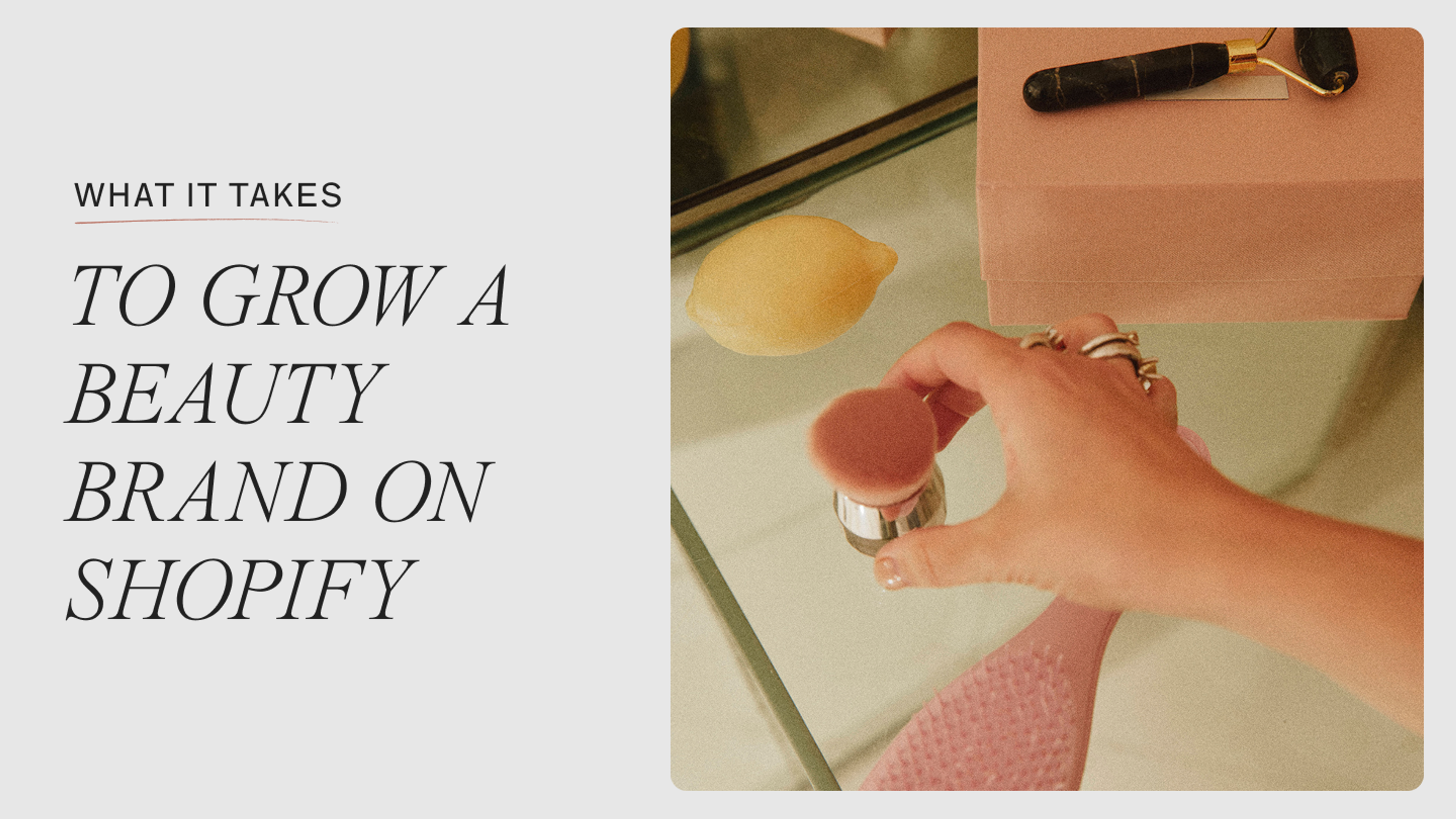 Woman applying blush at a mirrored vanity with a jade roller and lemon