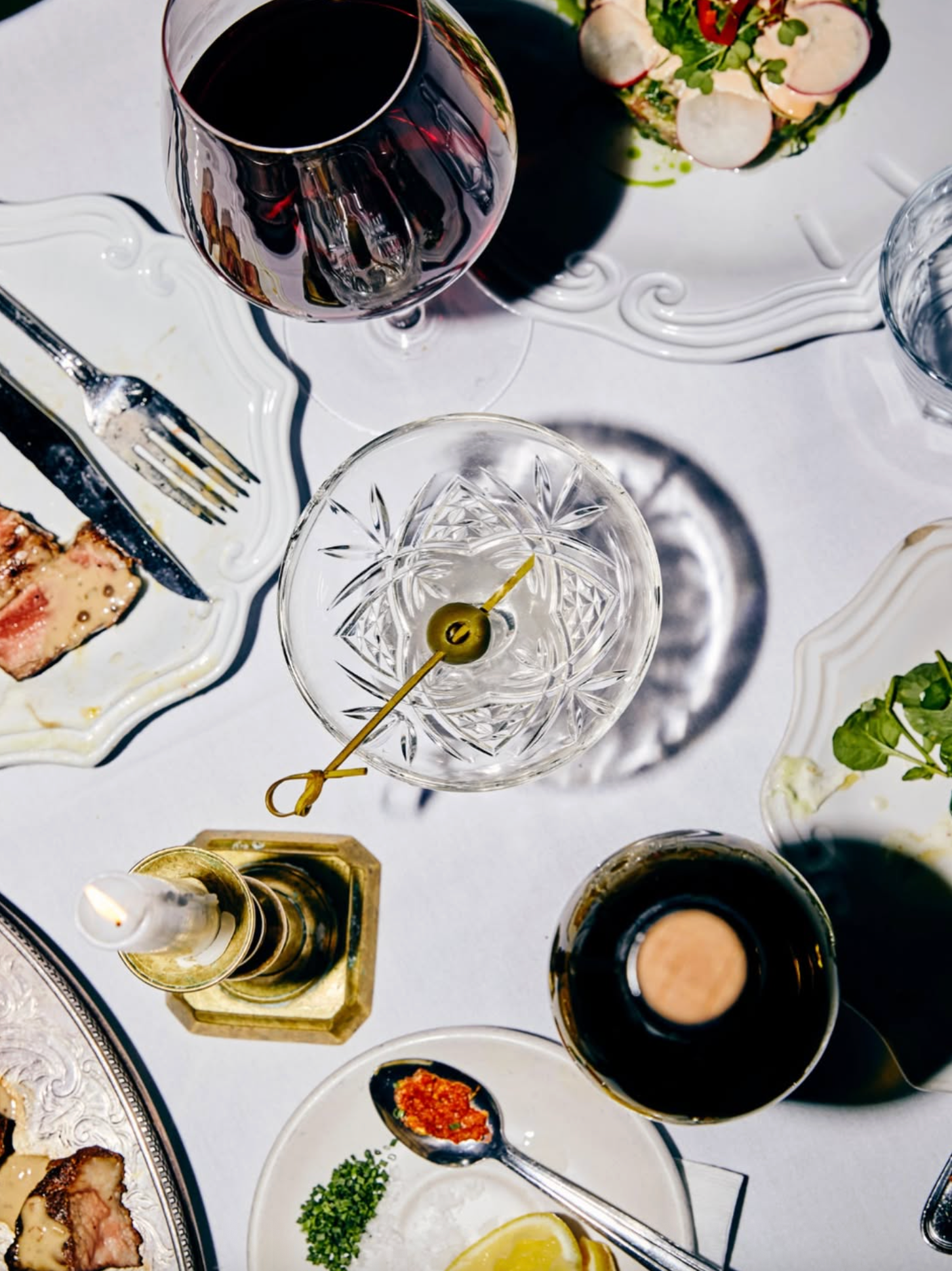 Cocktail glasses and cutlery on a set dinner table