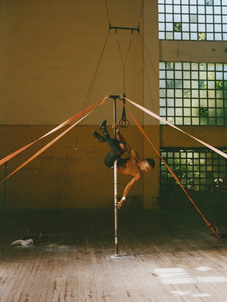 Left to right: Israel Ignacio Olivares Méndez and Yosdanis Font Crespo assist in lifting Amanda Boggiano Pardo during a balancing routine rehearsal. | Damian Dinza González performs an acrobatic routine on a suspended pole
