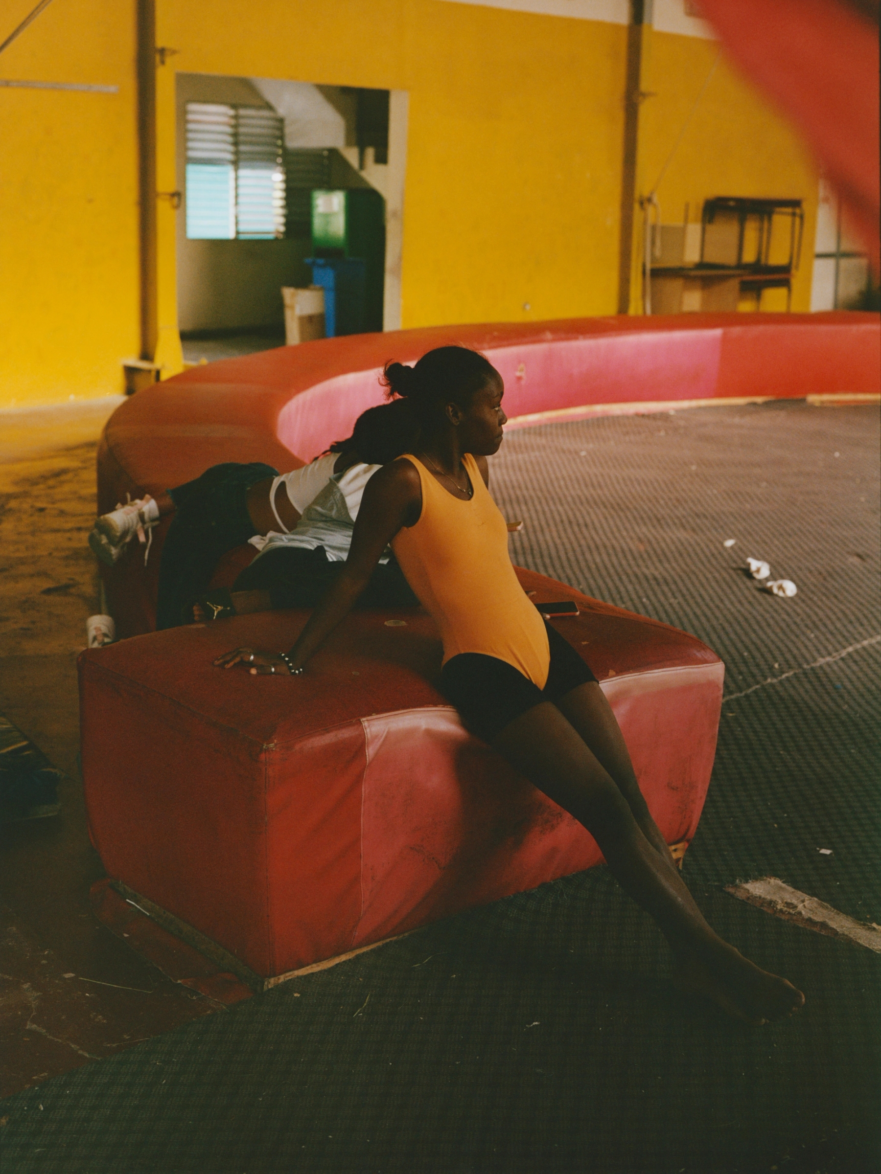 Daina Saibel Saldivar Estevez takes a break between rehearsals, finding a quiet moment amid the intensity of circus training.
