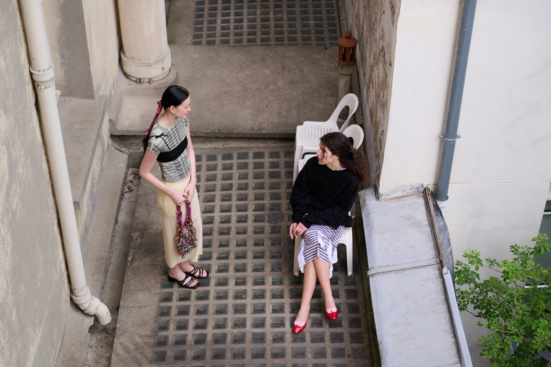 Left to right: Aline in Top Roa, Bra ATH, Skirt RIER, Shoes Justine Clenquet, Earrings Bérries, Bag Mathilde Hiron | Sofija in Dress & Sweater Seconda Paris, Shoes Repetto, Earrings Camille Surault, Socks Stylist’s own 
 
