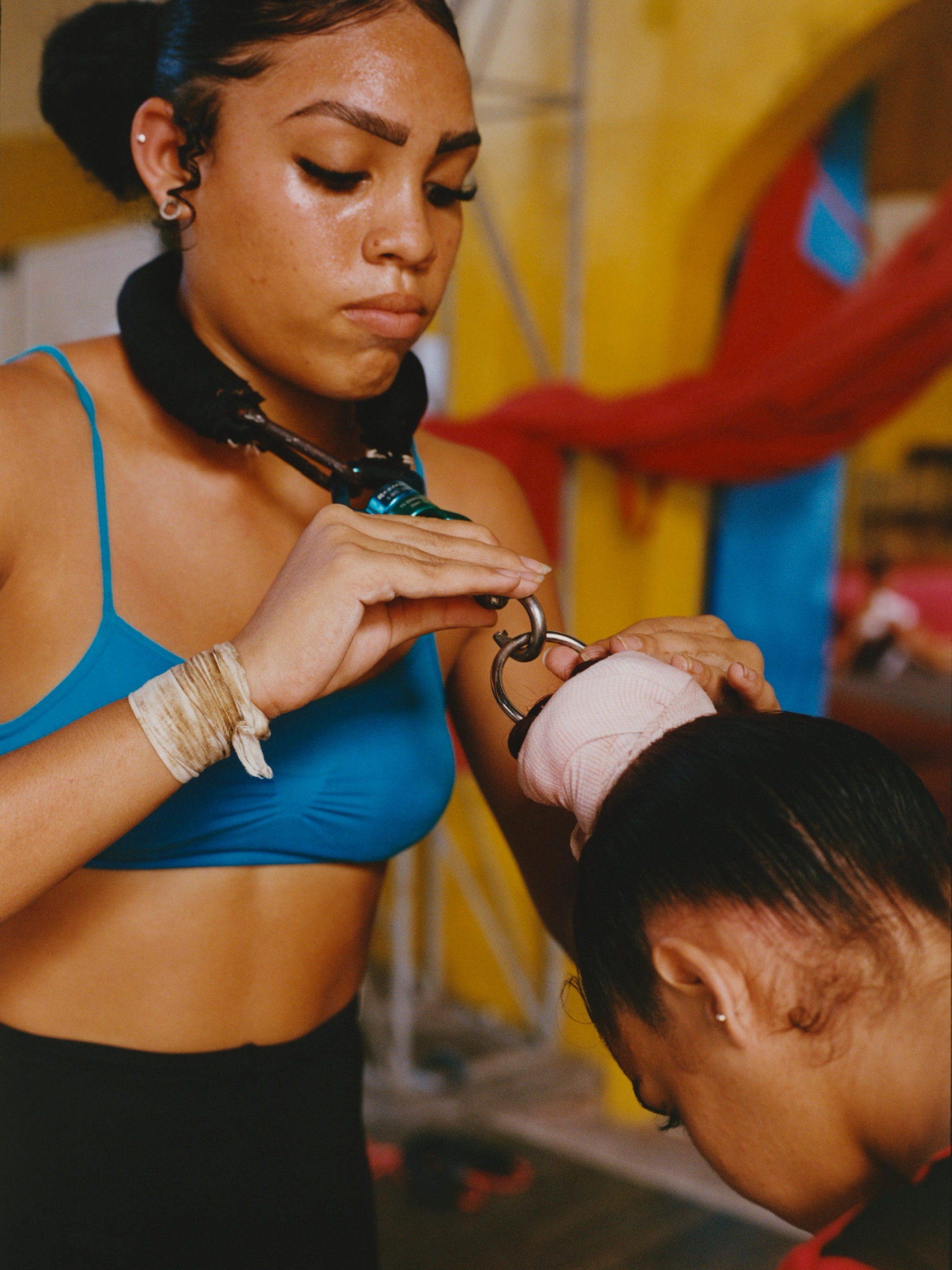 Rosselyn Quintana Ros clips in Yaimaris Alfonso López as they prepare to rehearse a high-flying roller-skate act.
