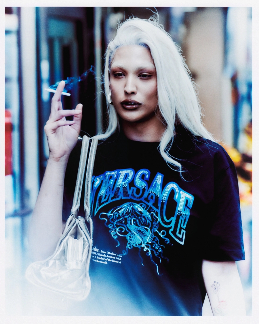 Left to right: T-shirt and bag stylist’s own, Earrings Justine Clenquet | T-shirt Versace, Bag stylist’s own, Earrings D’Heygere 
