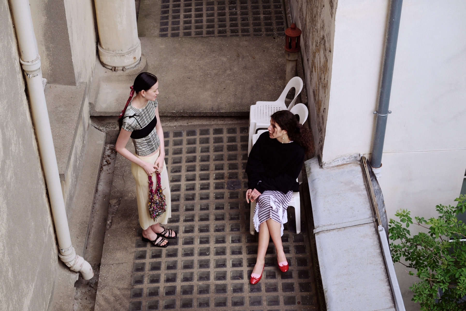 Left to right: Aline in Top Roa, Bra ATH, Skirt RIER, Shoes Justine Clenquet, Earrings Bérries, Bag Mathilde Hiron | Sofija in Dress & Sweater Seconda Paris, Shoes Repetto, Earrings Camille Surault, Socks Stylist’s own 
 
