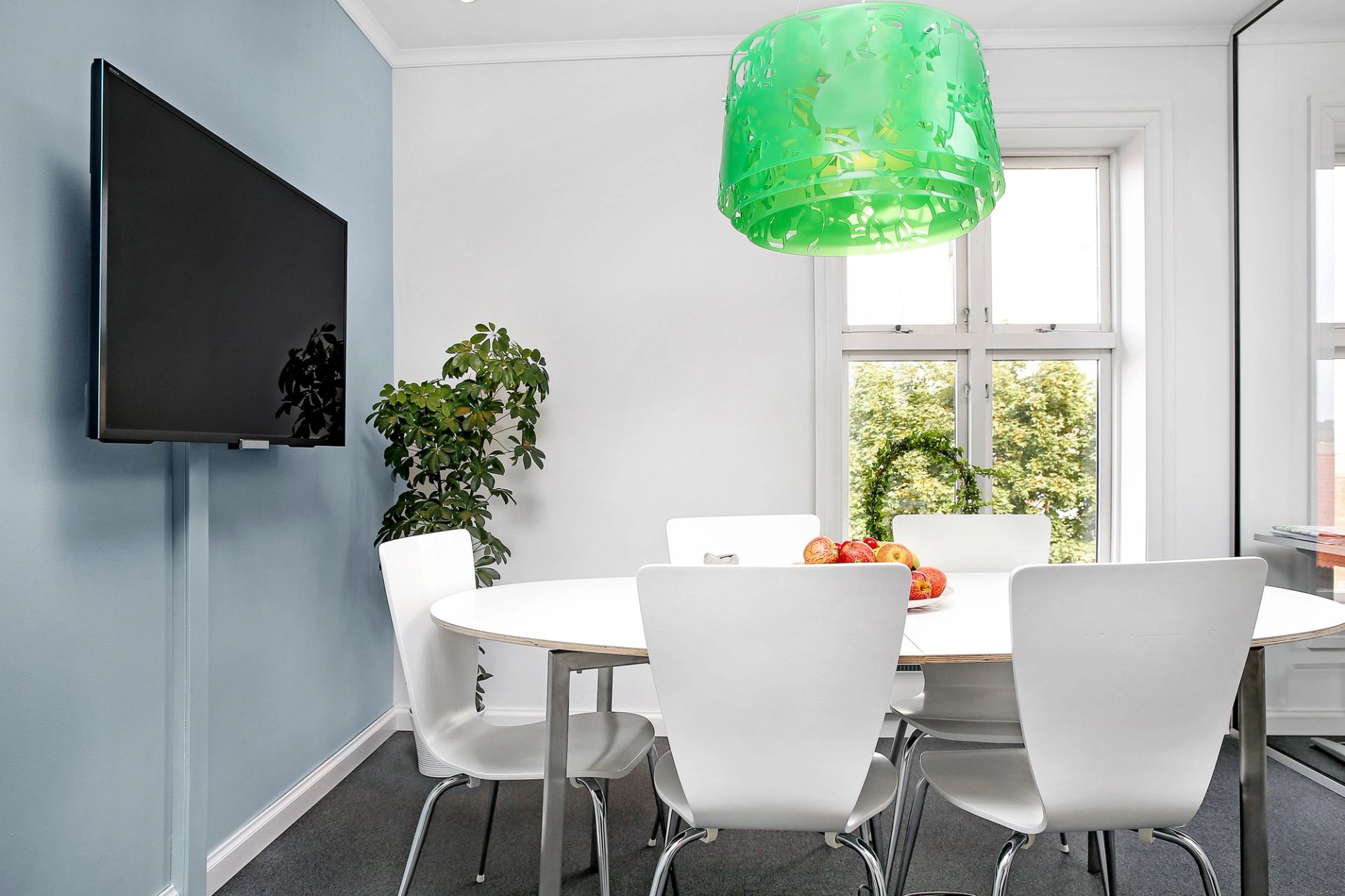 Bilde av møterom med plass til 5-6 personer med glassvegger mot åpent landskap og vindu med dagslys