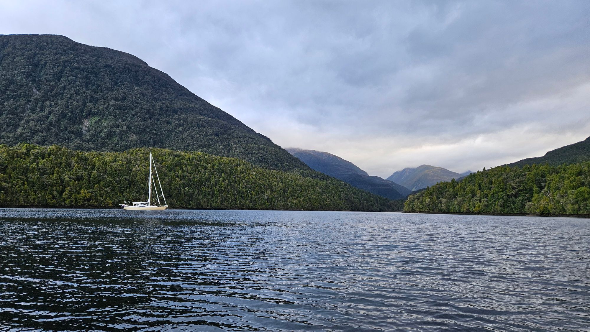 Matariki III at anchor alone in Lake Cove, Chalky Inlet, surrounded by native forest and mountains