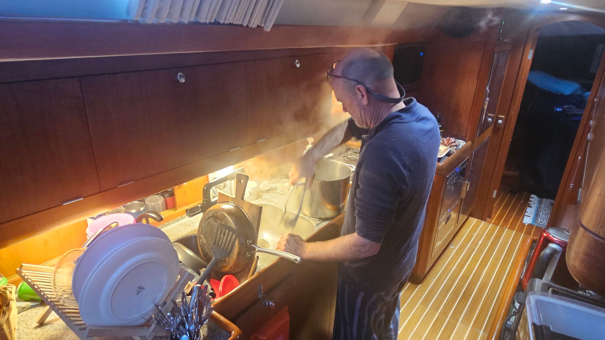 Bruce at Matariki III's galley, stirring a large pot of seafood chowder with steam rising