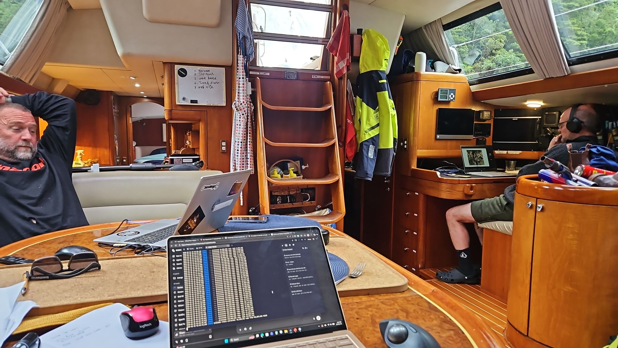 Crew working on laptops at Matariki III saloon table in Harrison Cove
