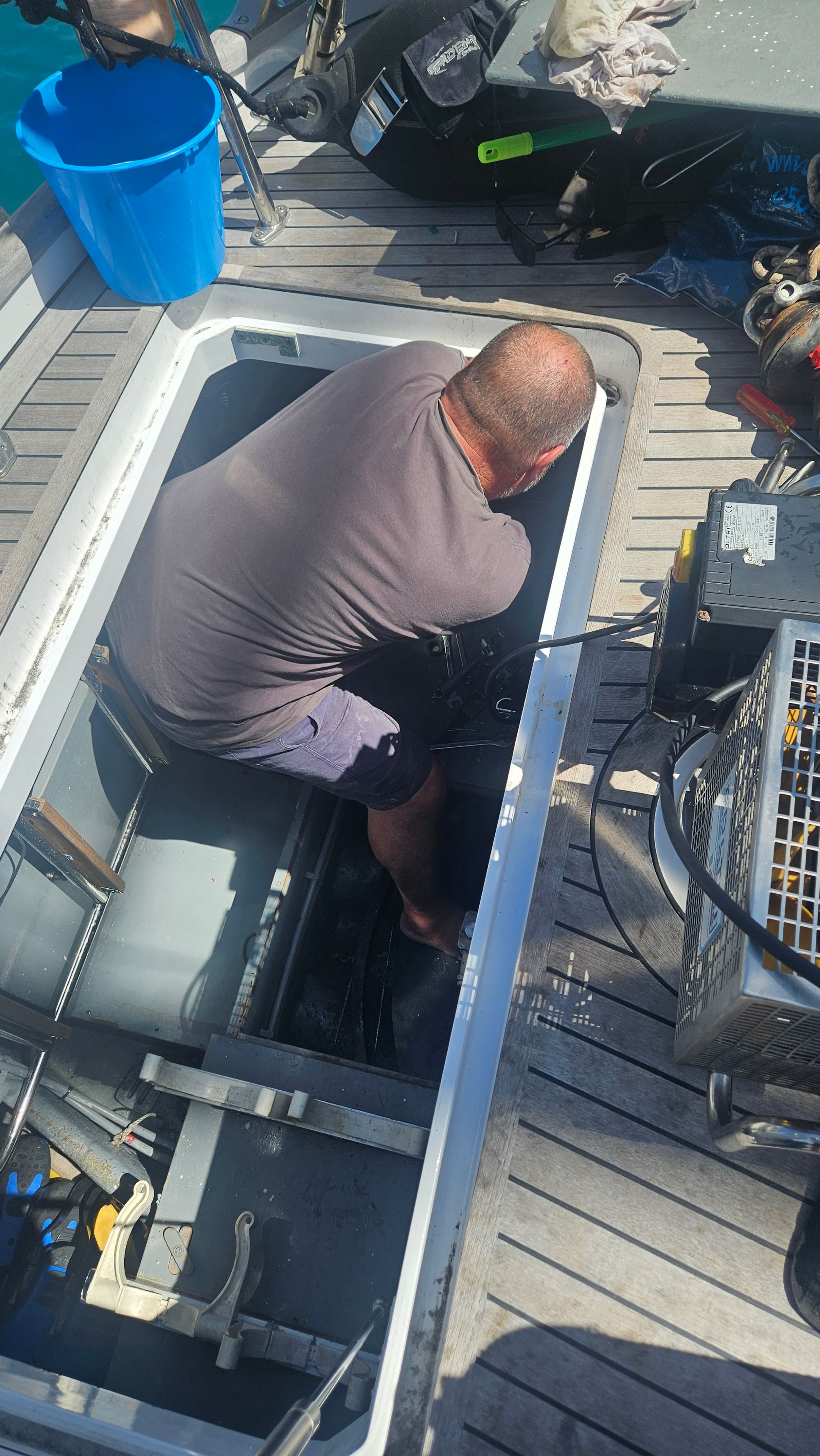 Brendan inspecting the steering system in the lazarette hatch on deck