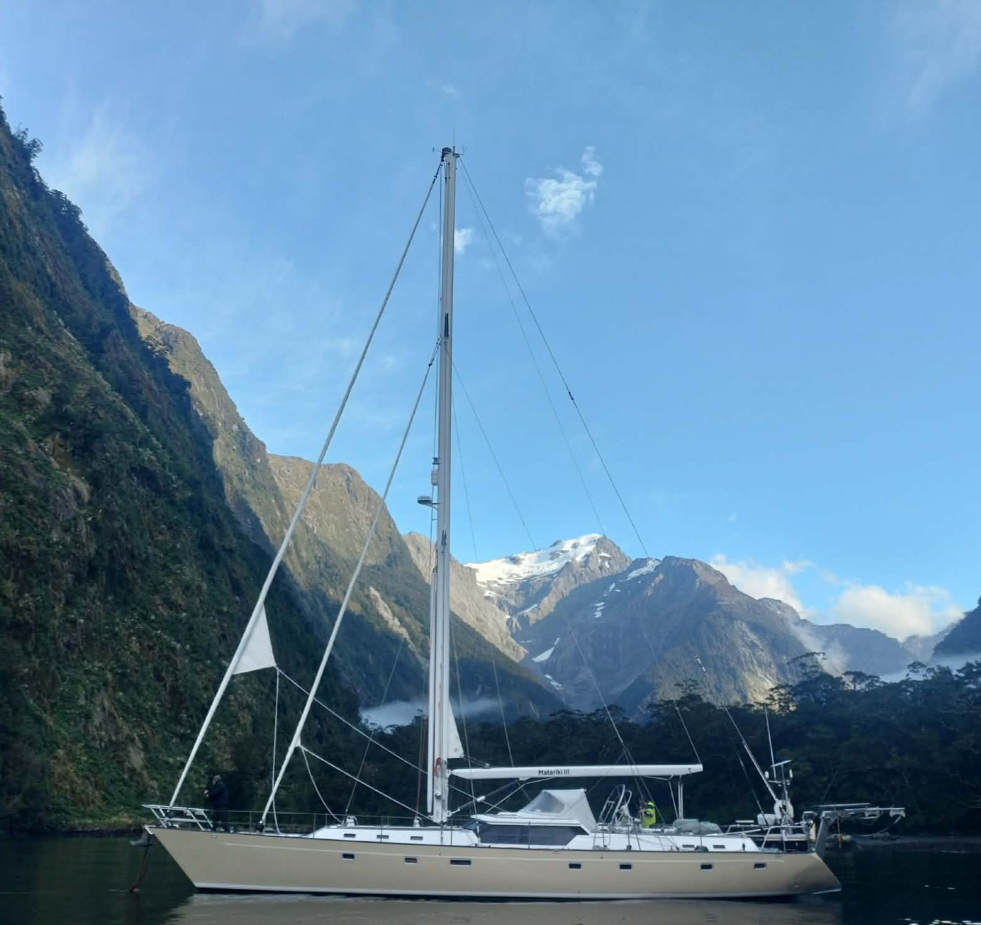 Matariki III at anchor in Milford Sound beneath snow-capped peaks