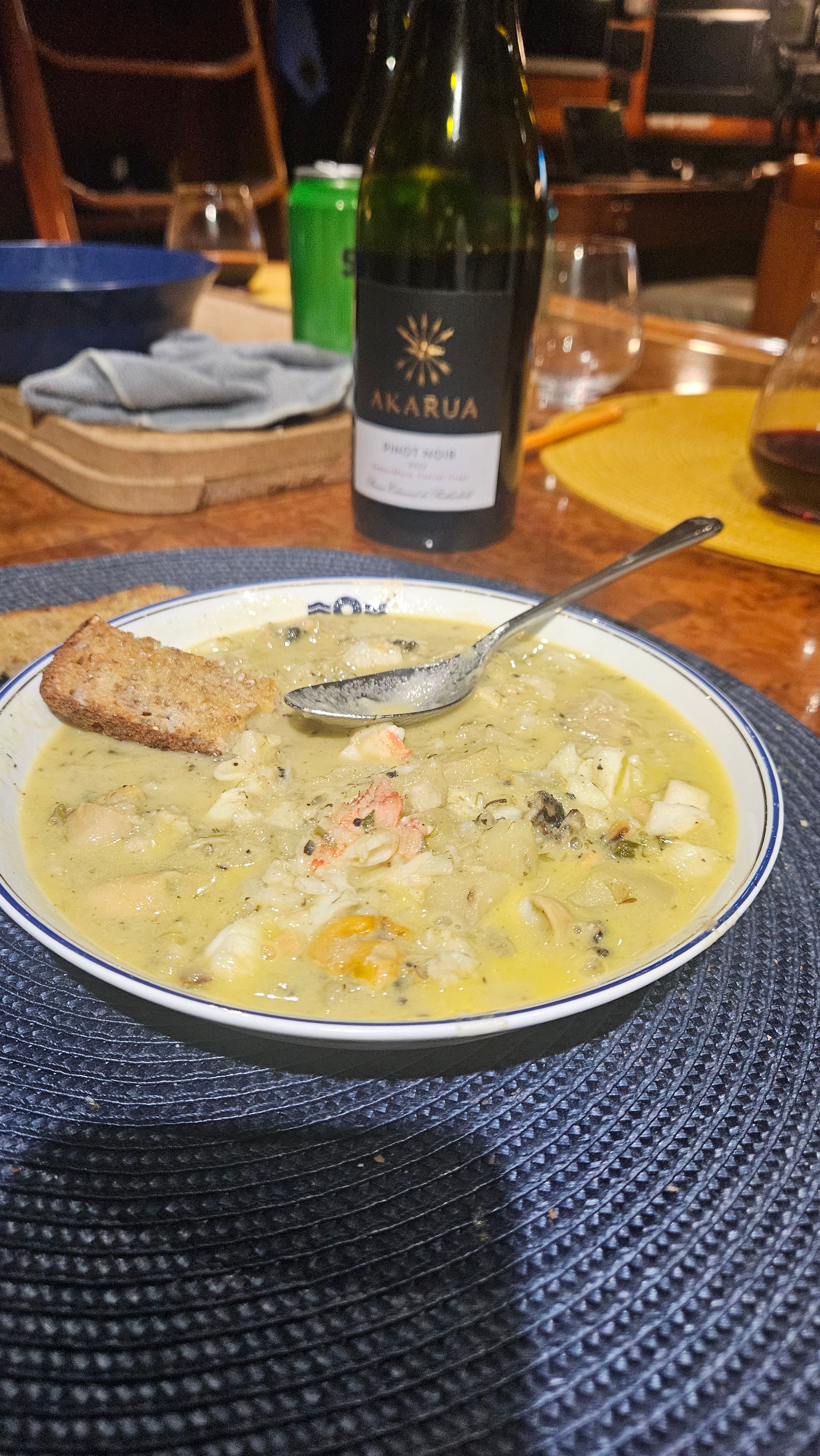 Bowl of Bruce's Fiordland seafood chowder with crusty bread and Akarua Pinot Noir