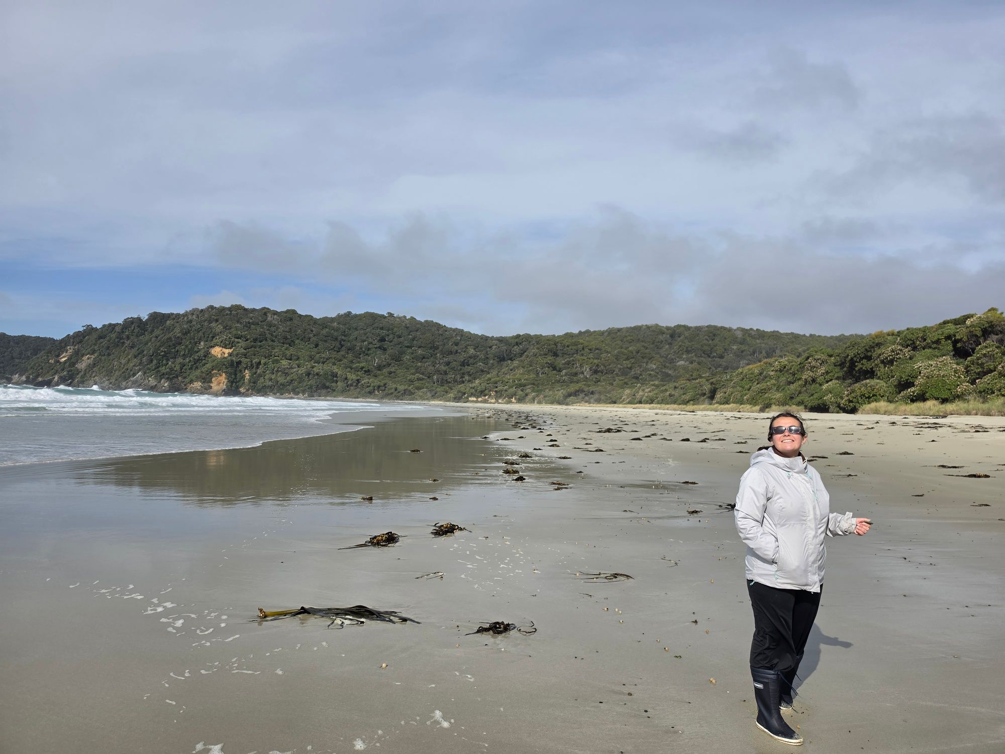 Jorja on Ocean Beach, Stewart Island — Southern Ocean swells rolling in behind