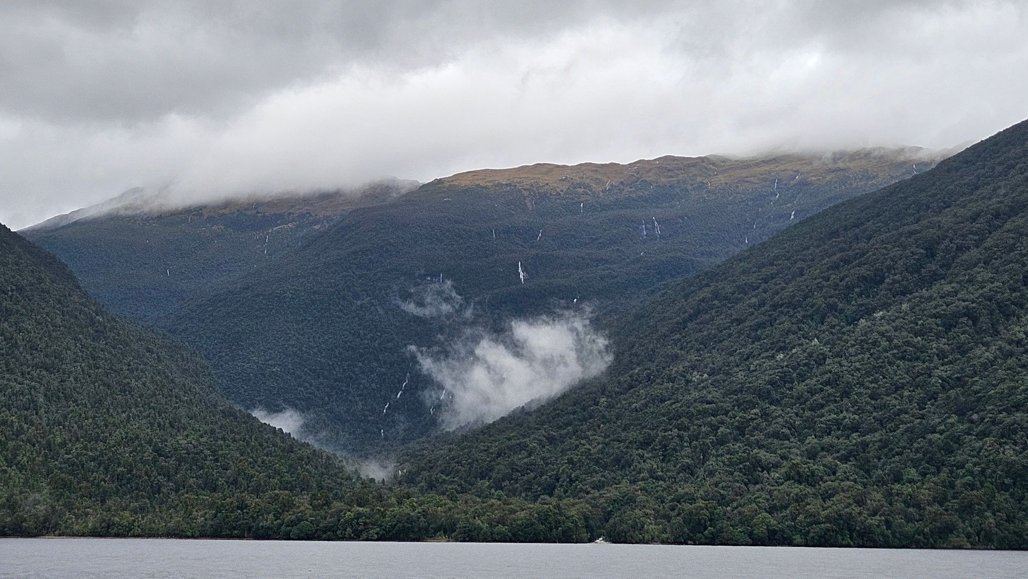 Sunny morning in Dusky Sound — deep valley reflections in perfectly still black water
