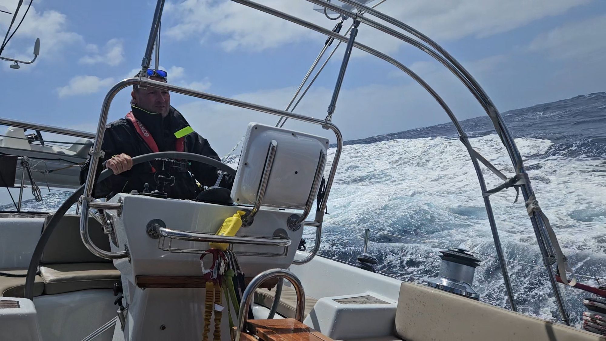 Matt at the helm of Matariki III in 40-knot conditions, large seas astern