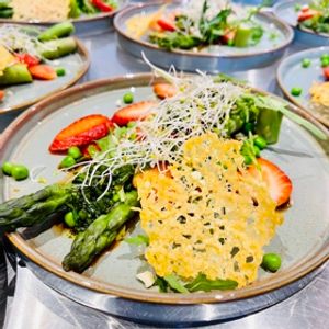 Photo de Salade de printemps aux asperges vertes, fraises et petits pois accompagnée d’une tuile au parmesan