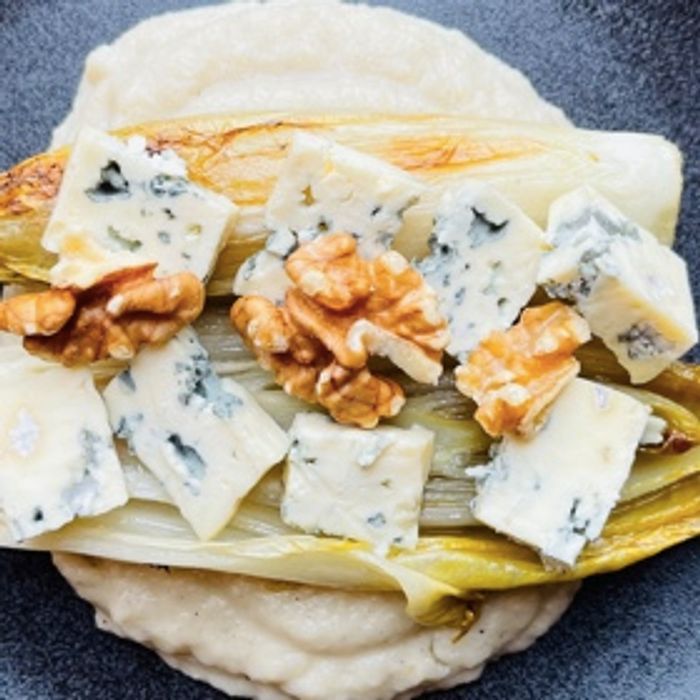Photo de Chicons braisés sur une crème de légumes racines blancs, pointe de cannelle et dés de roquefort