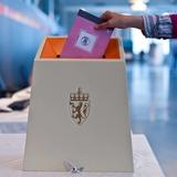 Personne votant dans une urne norvégienne