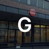 Lettre G en premier plan avec un batiment de NAV en arrière plan