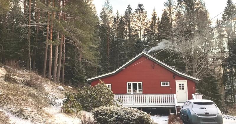 Maison rouge sous la neige entourée de fôret