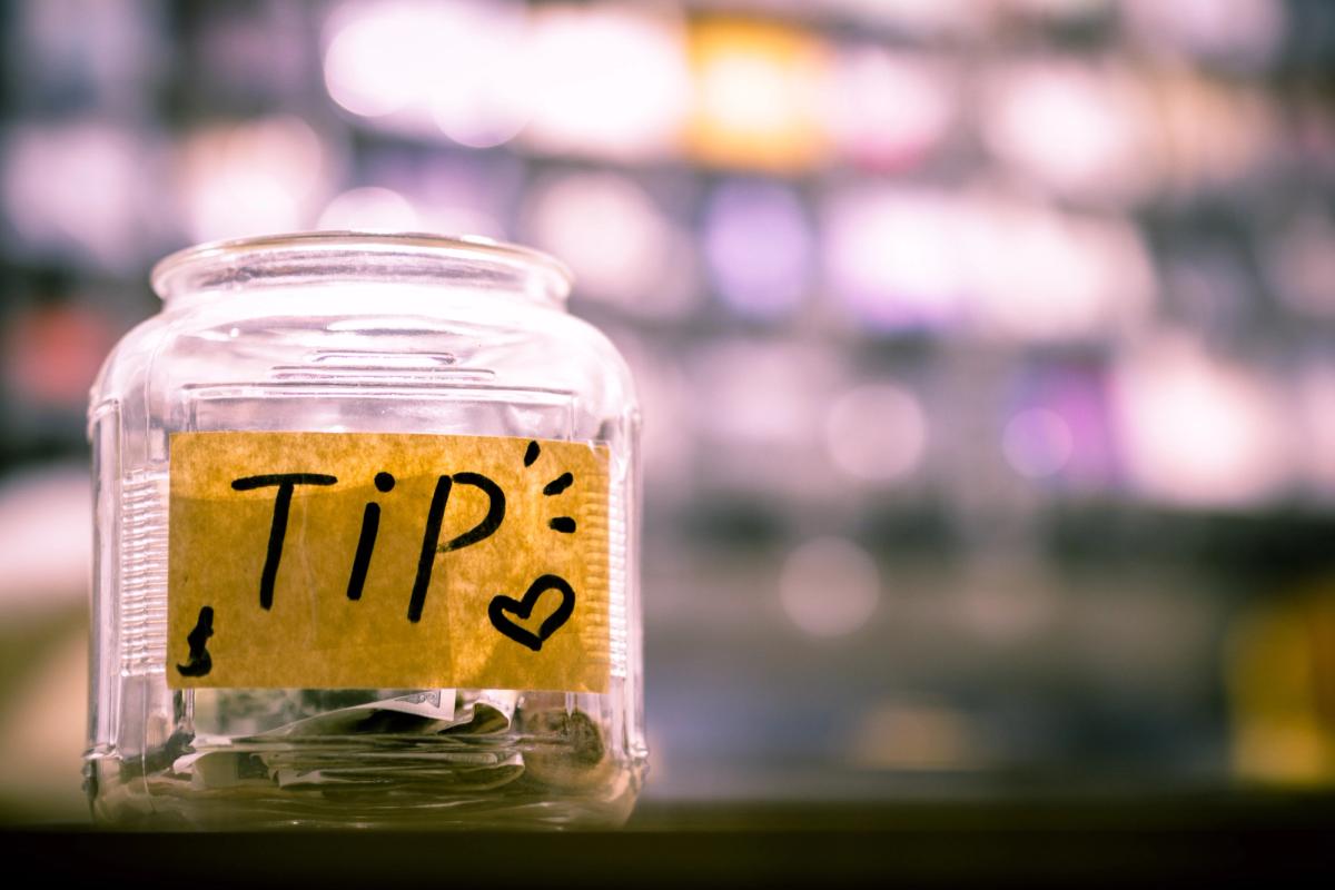 Un pot en verra avec une étiquette « Tip » collée dessus