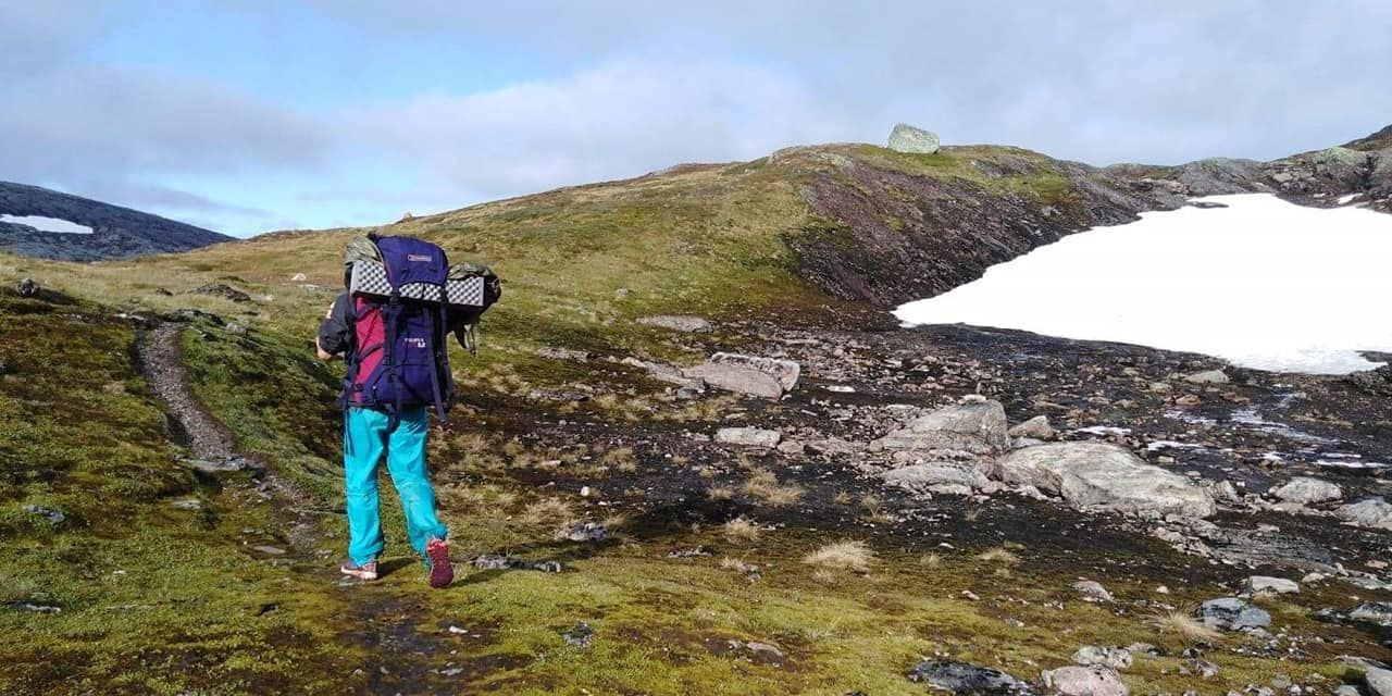 Olivia sur un chemin de montagne avec un névé pas loin
