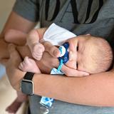 Un nouveau-n'e dans les bras d'un adulte