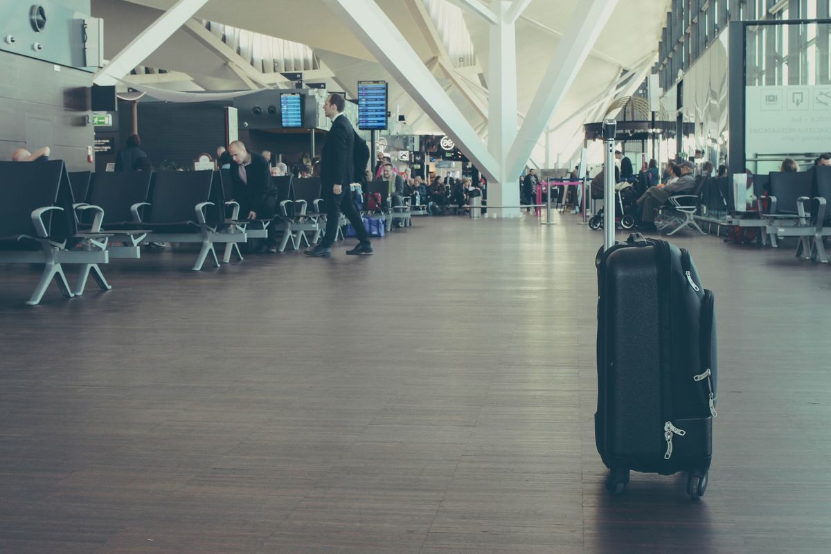 Hall d'aéroport avec une valise seule en premier plan