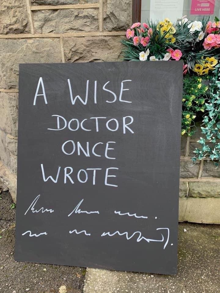 Une pancarte de moquant de l'écriture des docteurs: « A wise doctor once wrote [texte indéchiffrable] »