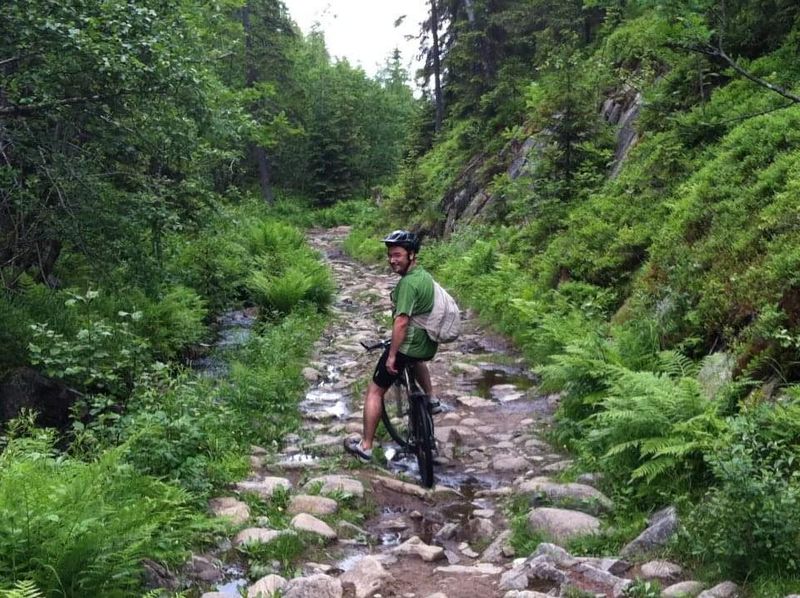 Lionel à vélo sur un sentier forestier