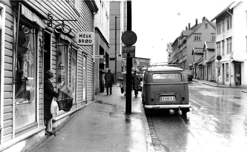 Photo en noir et blanc d'une rue avec une boutique « Melk og brød »