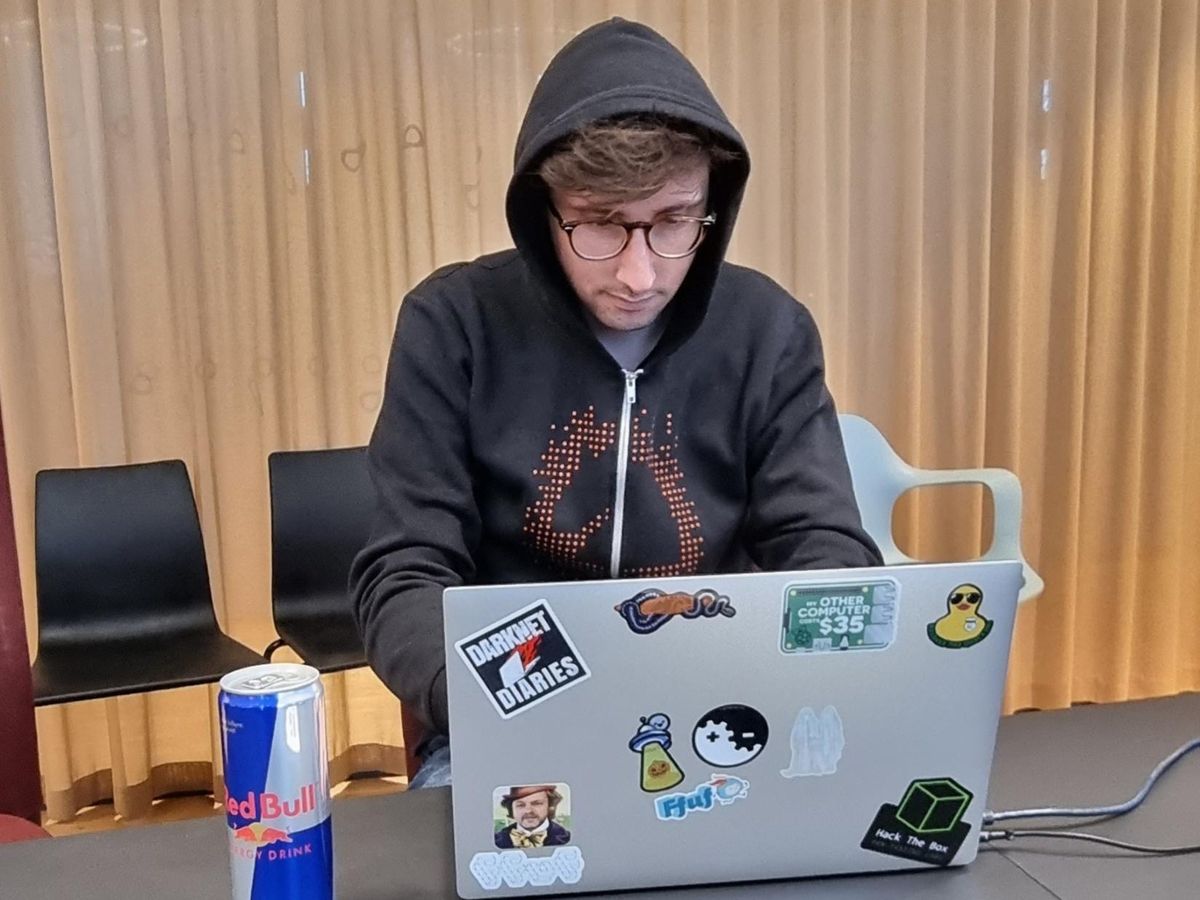 Portrait de Camille devant son ordinateur avec son pull à capuche de « hacker »
