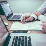 Personnes travaillant sur un bureau devant un ordinateur