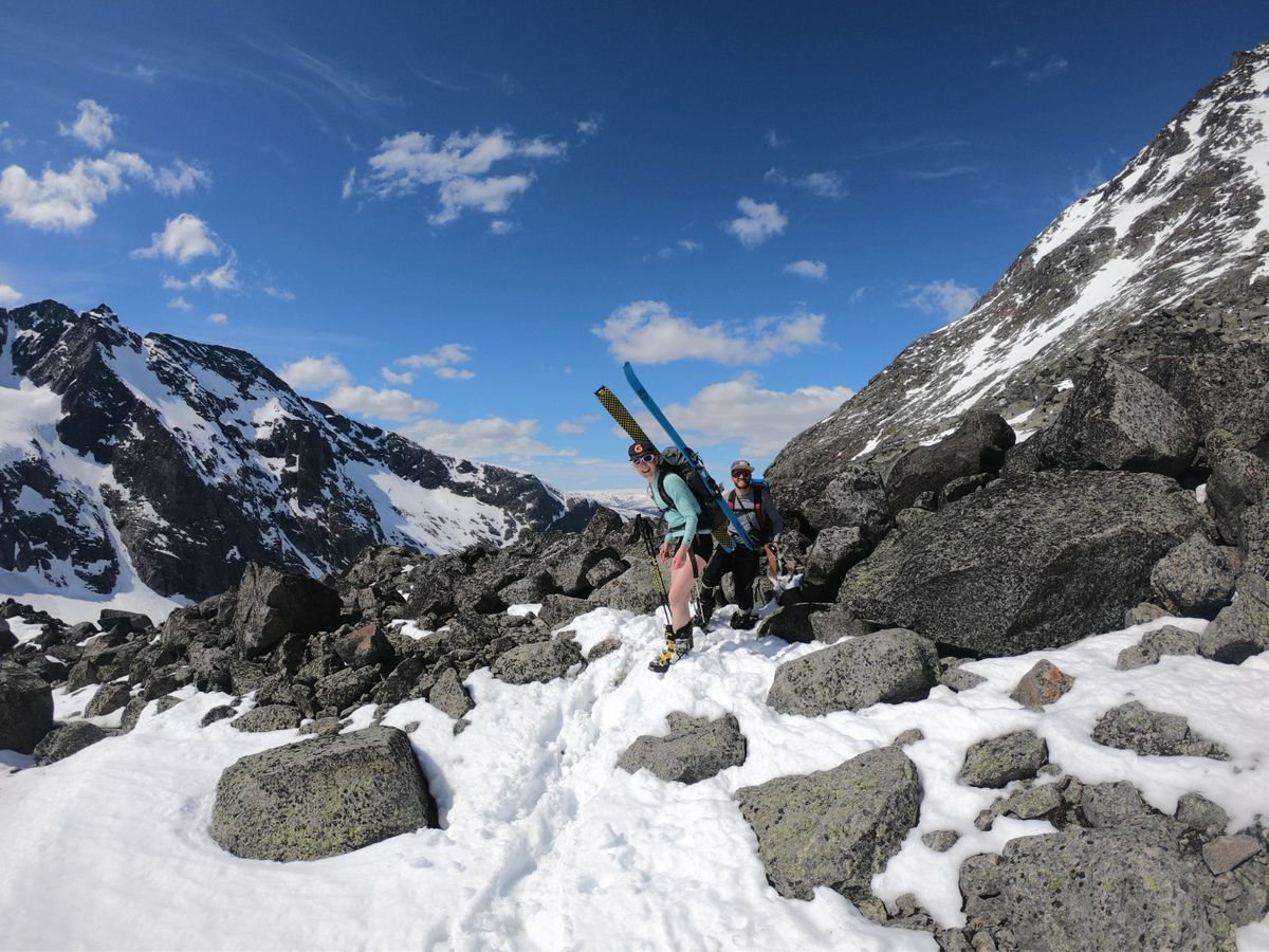 Marion et Tristan sur de la neige avec les skis sur le dos