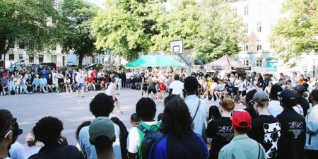 A crowd of people around a basketball court
