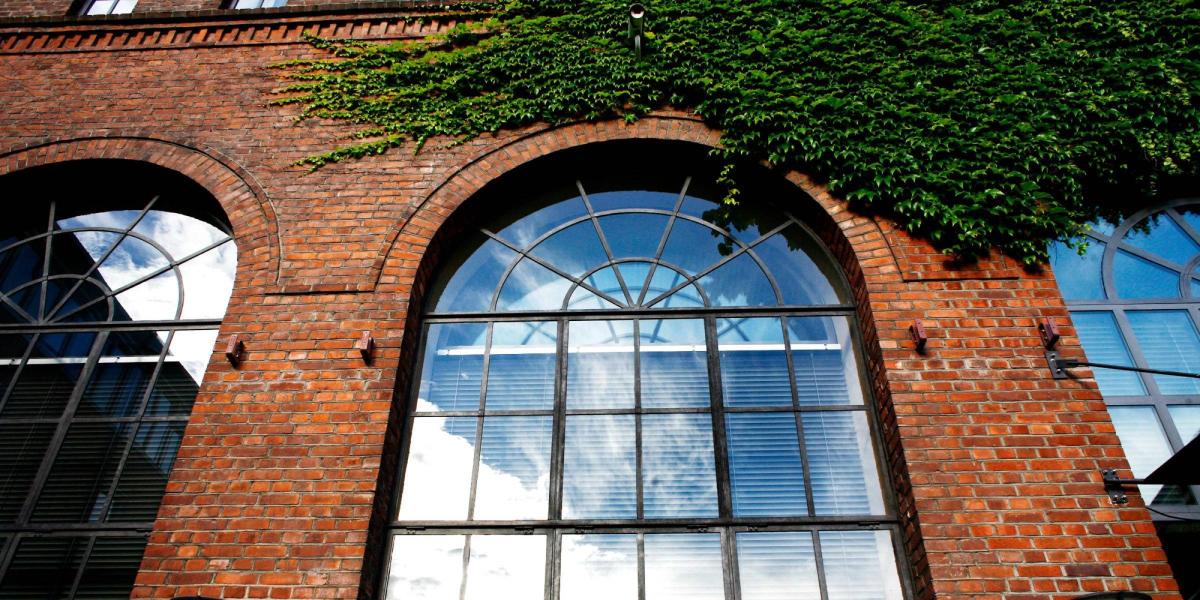 Fasadebilde av Fyrhuset på OsloMet med fokus på et stort ovalt avrundet vindu med sorte sprosser.