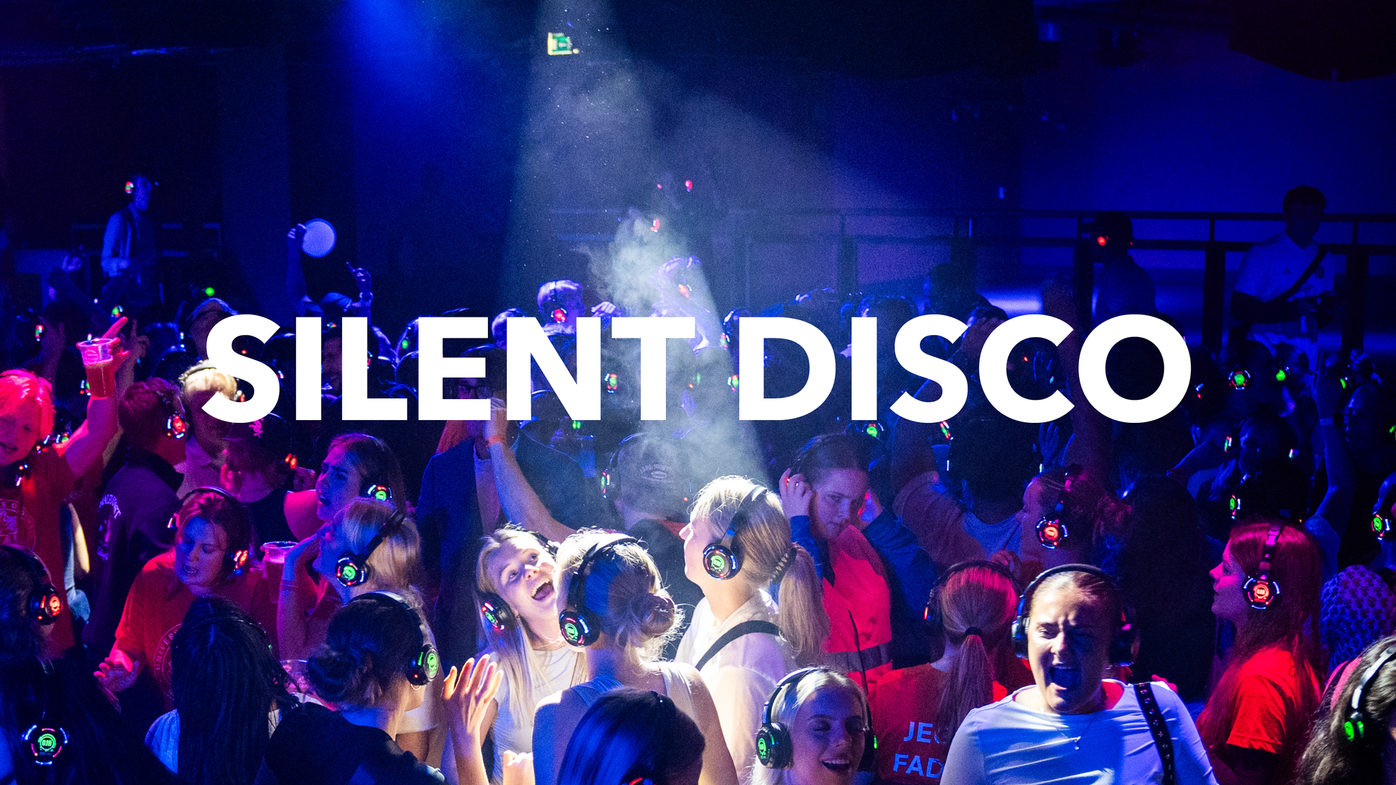 A crowded silent disco dance floor glows under blue and pink lights as partygoers wear illuminated wireless headphones, with large white “SILENT DISCO” text across the image.