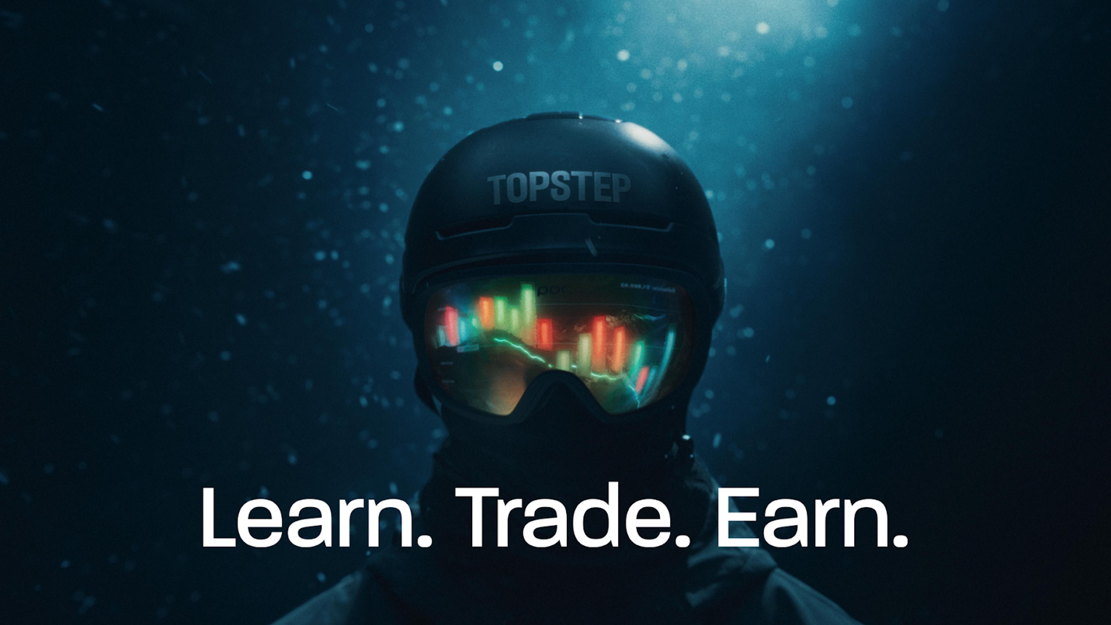 Skier with a black Topstep branded helmet with glowing candlesticks reflected in their goggles.