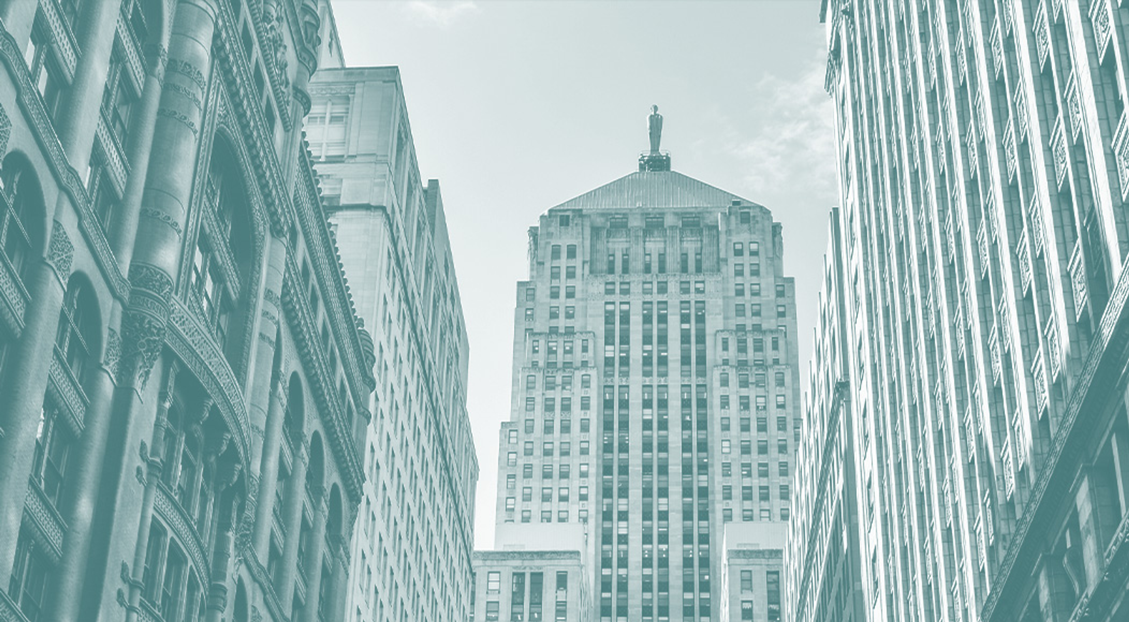 Tall office buildings framing a central skyscraper in a downtown city scene.