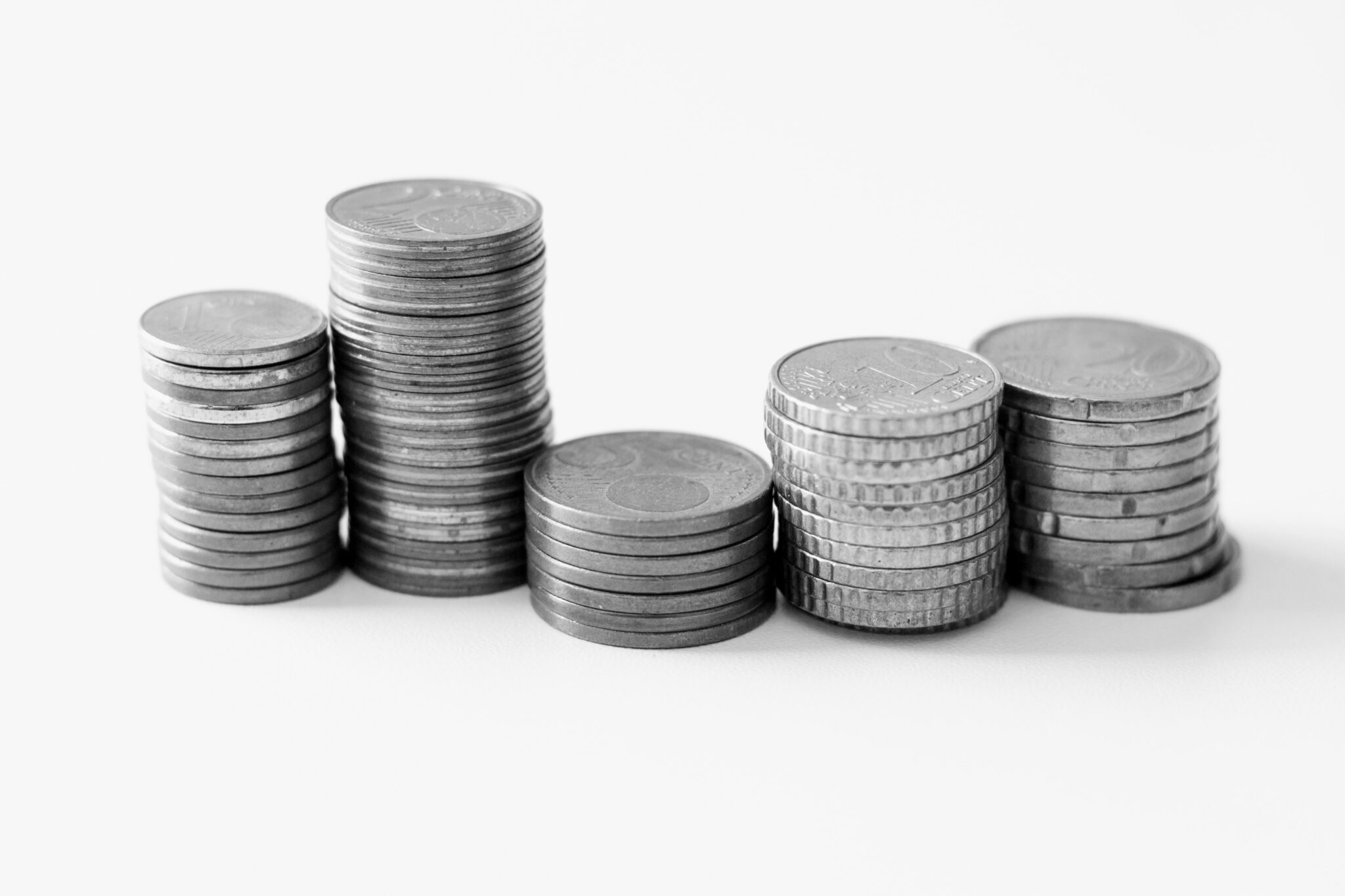 Black and white image of stacked coins on a white background.