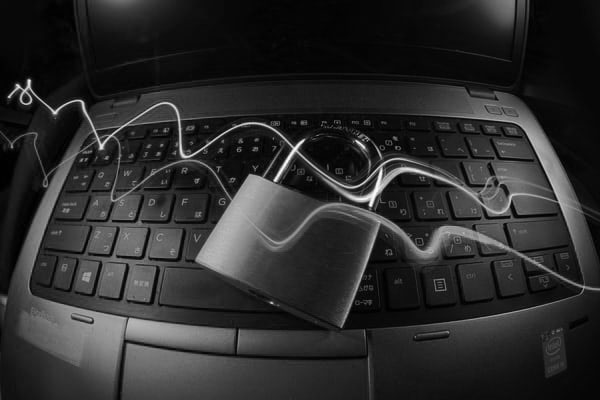 Padlock resting on a laptop keyboard, symbolizing digital security.