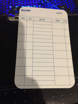 Blank buyer transaction log card on a wallet with a blue-lit keyboard behind it.