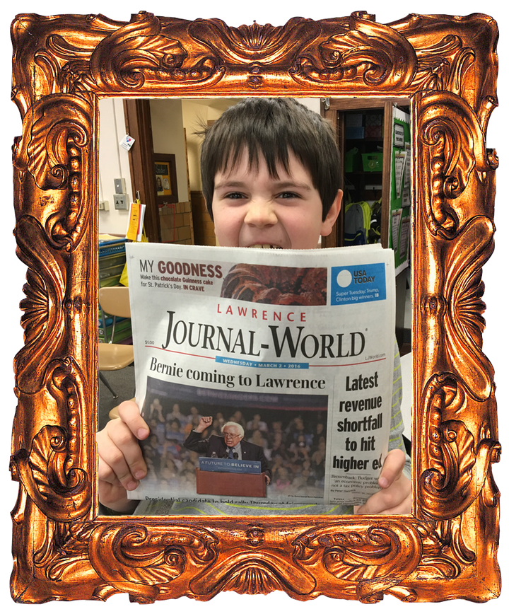 A young Charlie Andrade holding up a Lawrence Journal-World front page headlined "Bernie coming to Lawrence"