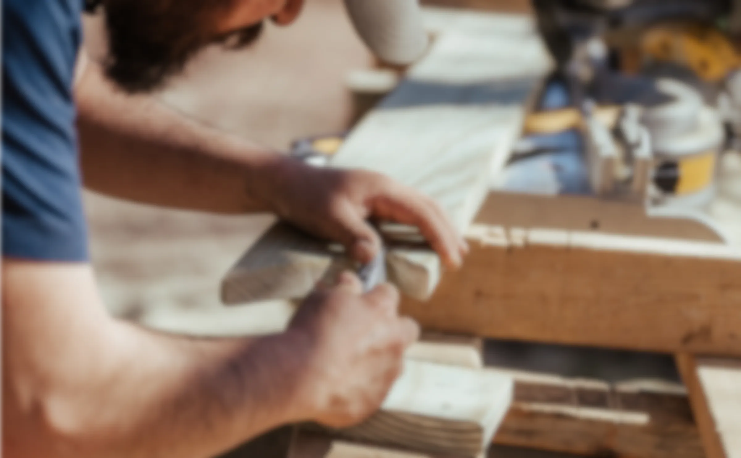 A carpenter working on a piece of timber.