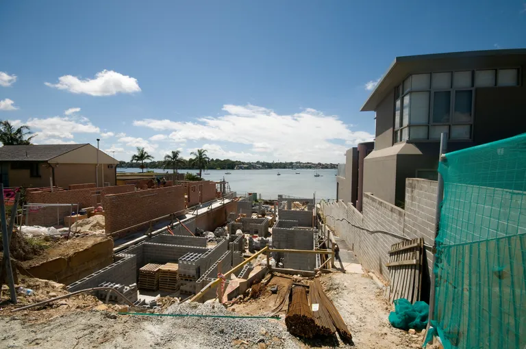 Bricklayers working on a waterfront residential construction site in Australia.