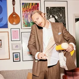A guy using a hair dryer after spilling on coffee on his shirt