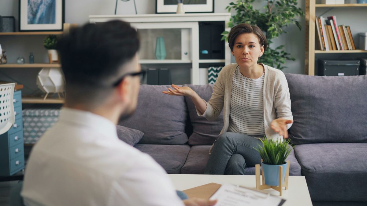 A real estate agent meeting with a buyer and seller together to explain dual agency in real estate during a home transaction.