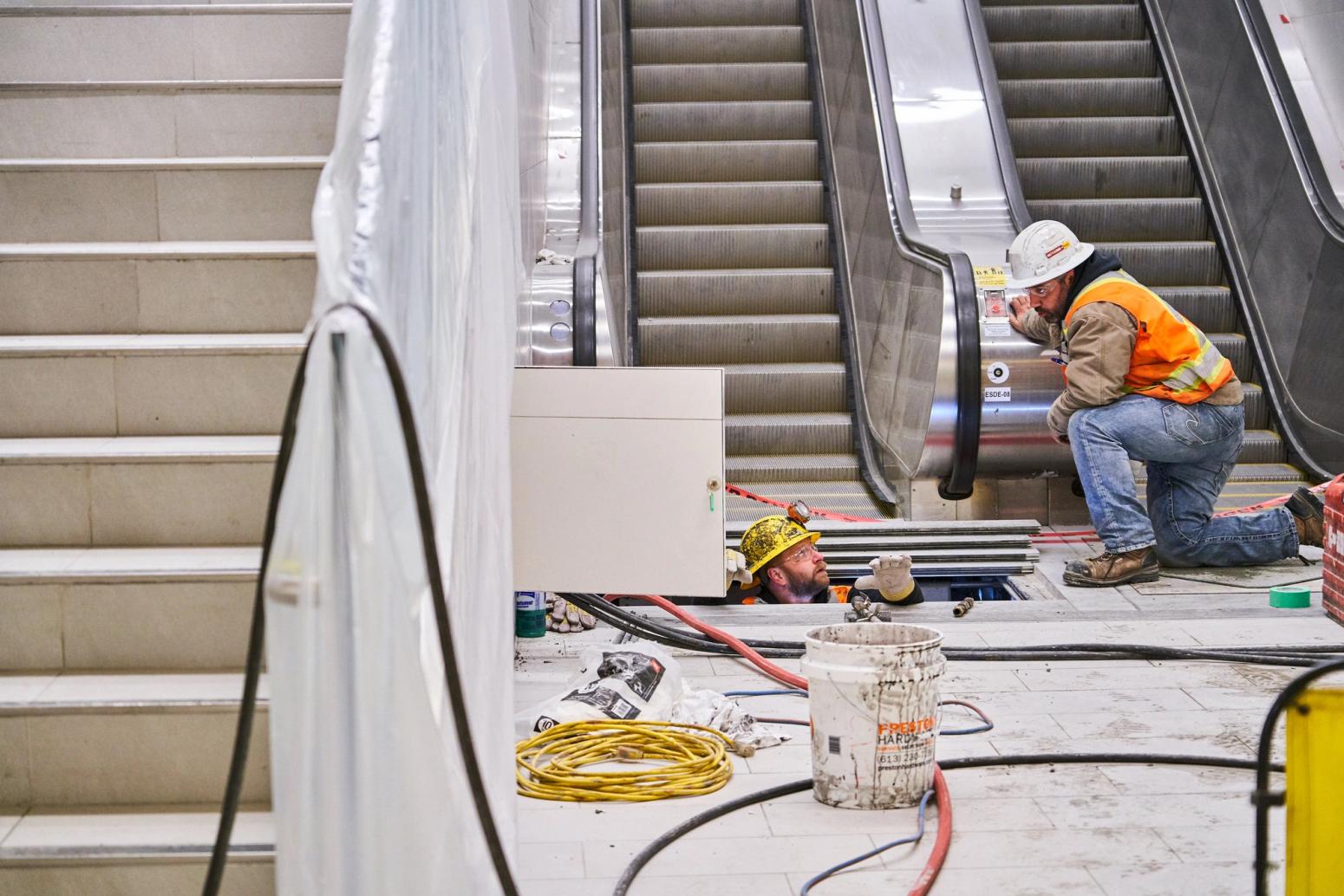 Workers installing escalator