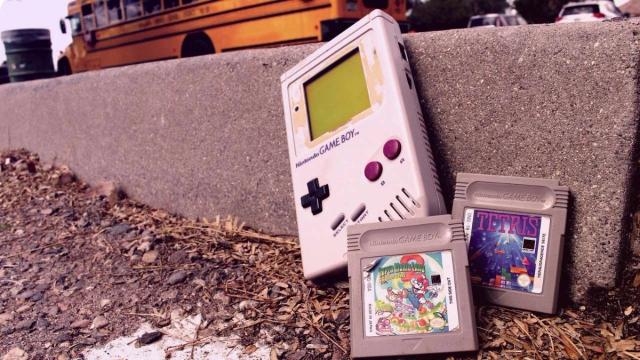 Photographie d'une gameboy avec deux cartouches le long d'un trottoir.